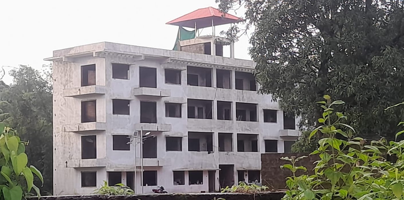 Paradise Homes B Wing seen across greenery with the rooftop pavilion in place